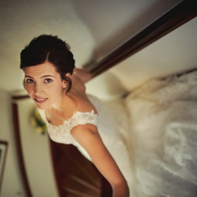 De bruid kijkt omhoog als ze de trap afwandelt