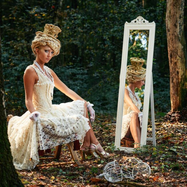 In smenwerking met the special guest een prachtige dame in het bos in een renaissance jurk voor een spiegel